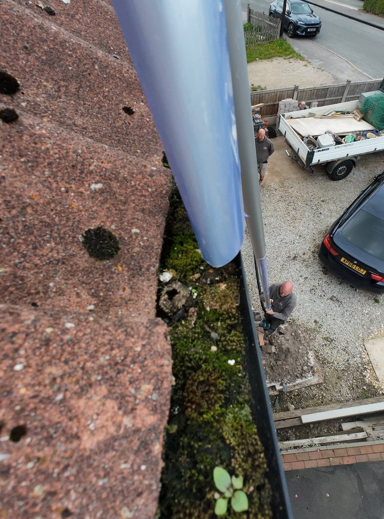 Moss and vegetation in the gutter beside the vacuum nozzle