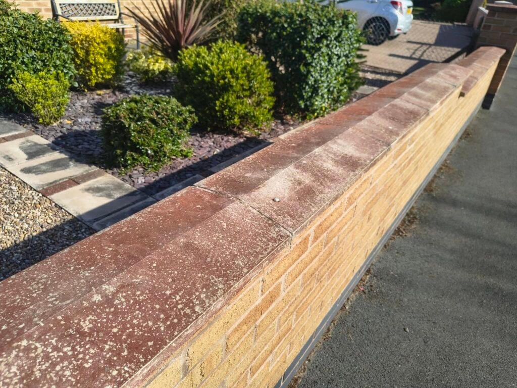 Reddish staining and lichen on Nuthall coping stones before cleaning